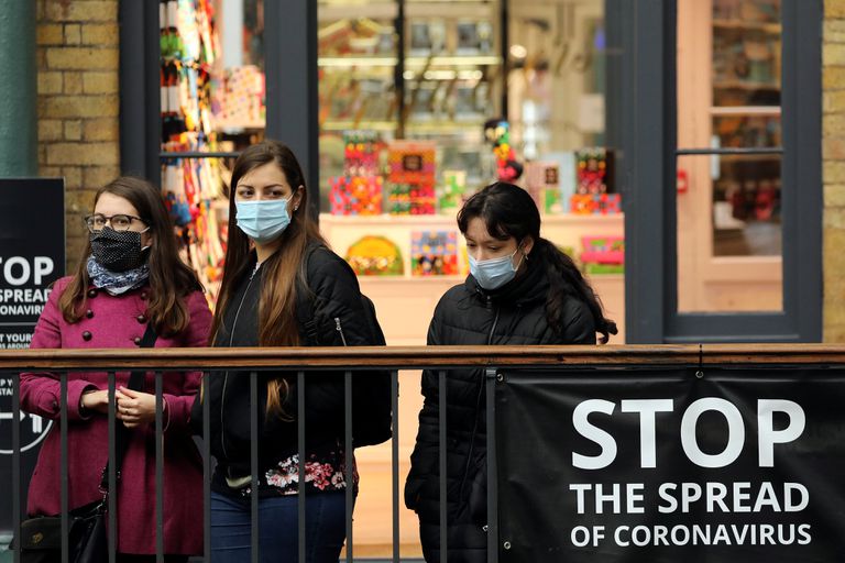 Vecinos de Londres, protegidos con mascarillas, en el exterior del Convent Garden.