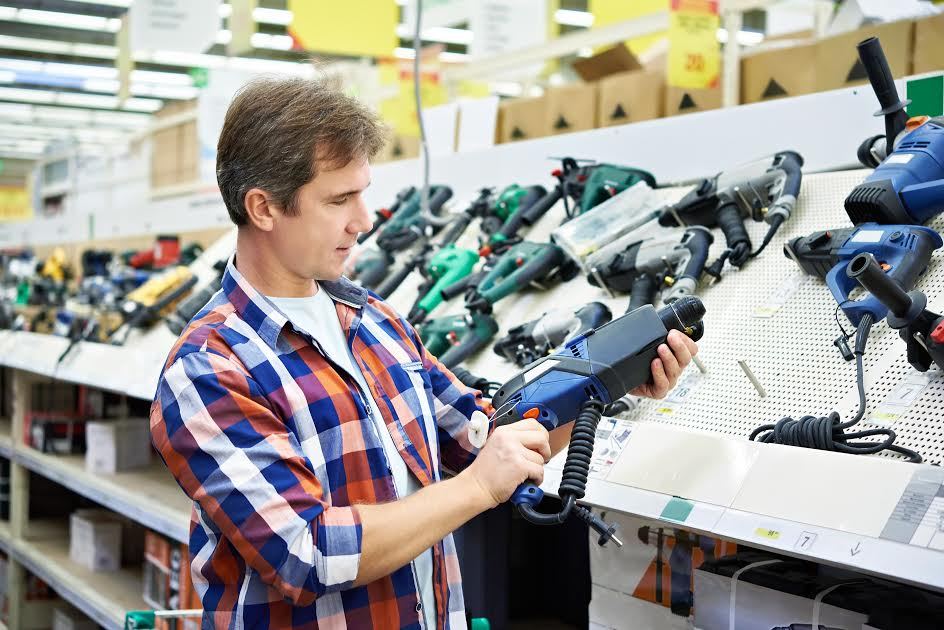 Un hombre para compras de herramientas eléctricas en una tienda. 