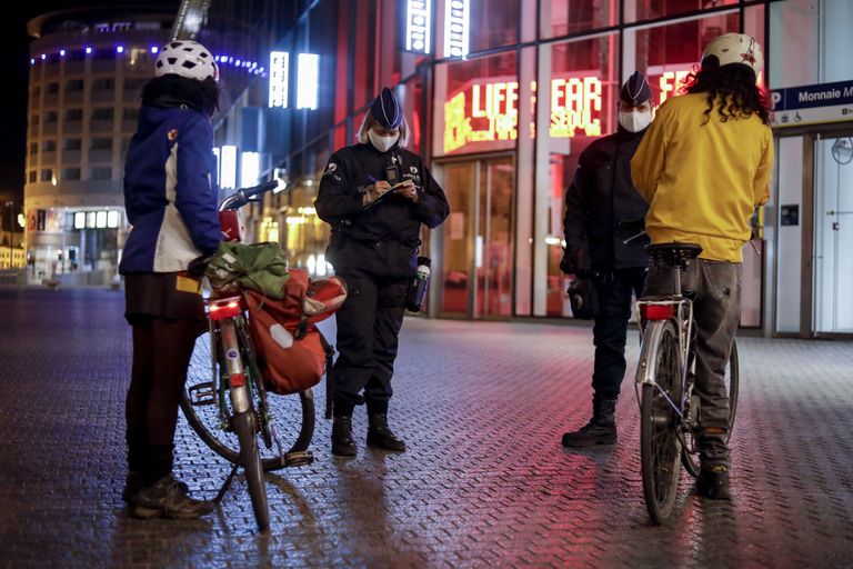 Policías belgas multan a dos ciclistas por violar el toque de queda, este martes en Bruselas.