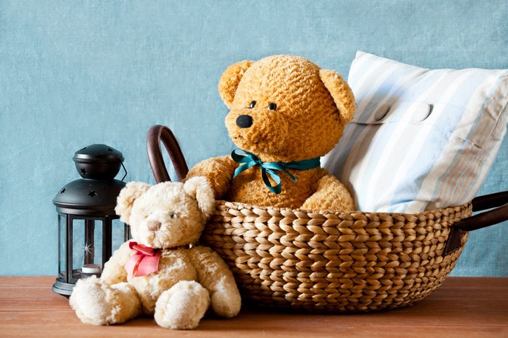 Un par de osos de peluche sentados en una canasta. 