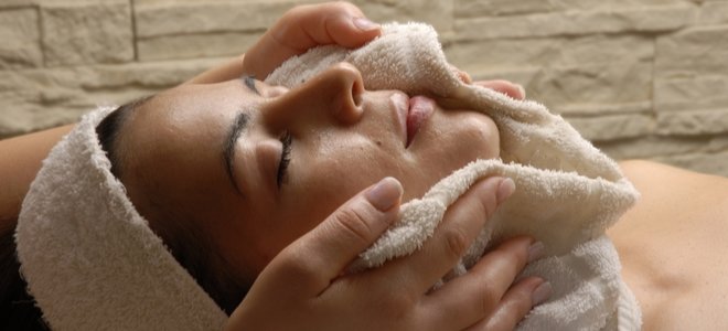 mujer con toalla caliente alrededor de su cara