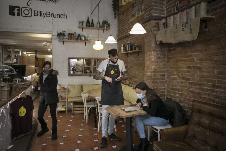 Un camarero atiende a una clienta en un bar del Eixample de Barcelona.