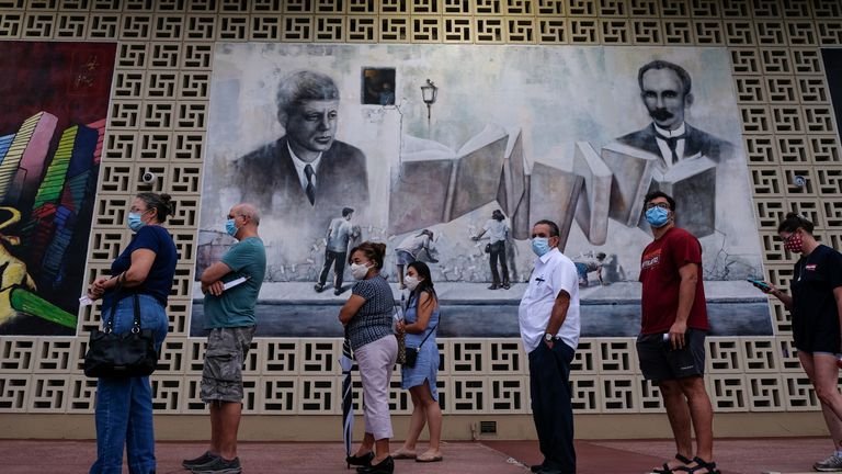 La gente hace fila en la mesa de votación de la Biblioteca John F. Kennedy, en el inicio de la votación anticipada en Hialeah, Florida, el 19 de octubre de 2020.