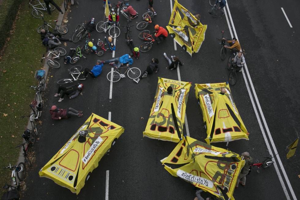 Los coches de madera y tela atropellan metafóricamente a los ciclistas.