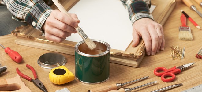 manos reparando marco de madera