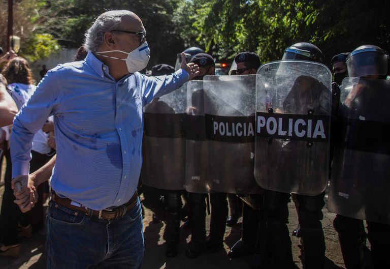 El periodista Carlos Fernando Chamorro, director de 'Confidencial', le reclama a la policía frente a las oficinas de su revista en Managua, el 14 de diciembre de 2020.