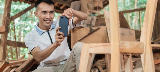 Hombre fotografiando una silla de madera en un taller