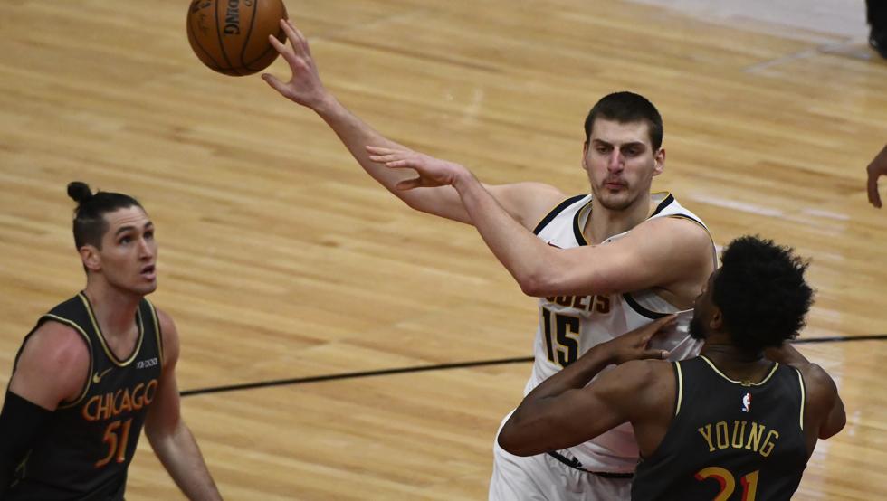 Nikola Jokic pasa un balón entre Ryan Arcidiacono y Thaddeus Young durante la victoria de los Denver Nuggets en casa de los Chicago Bulls