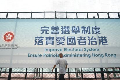 Un hombre pasa este martes ante un cartel en Hong Kong que promueve la reforma del sistema electoral.