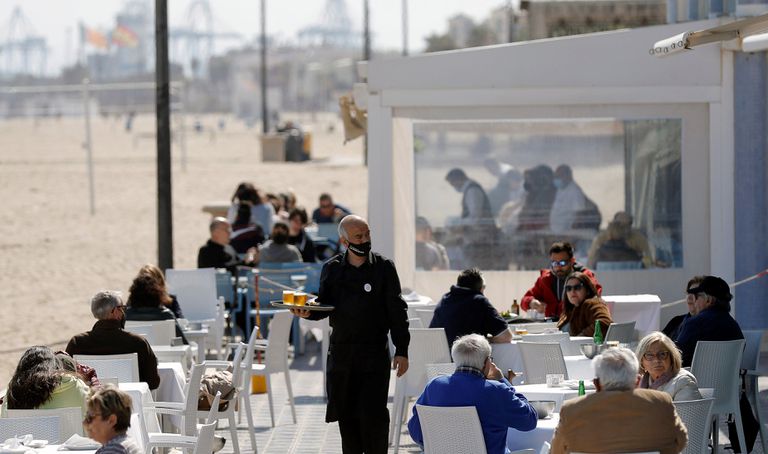 Un camarero atiende las mesas de una terraza en uno de los restaurantes de la playa de la playa de la Malvarrosa de Valencia el 15 de marzo.
