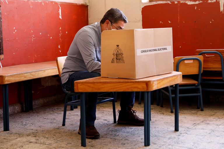 El presidente de Honduras, Juan Orlando Hernández, vota durante las elecciones primarias en Lempira, Honduras, el 14 de marzo.