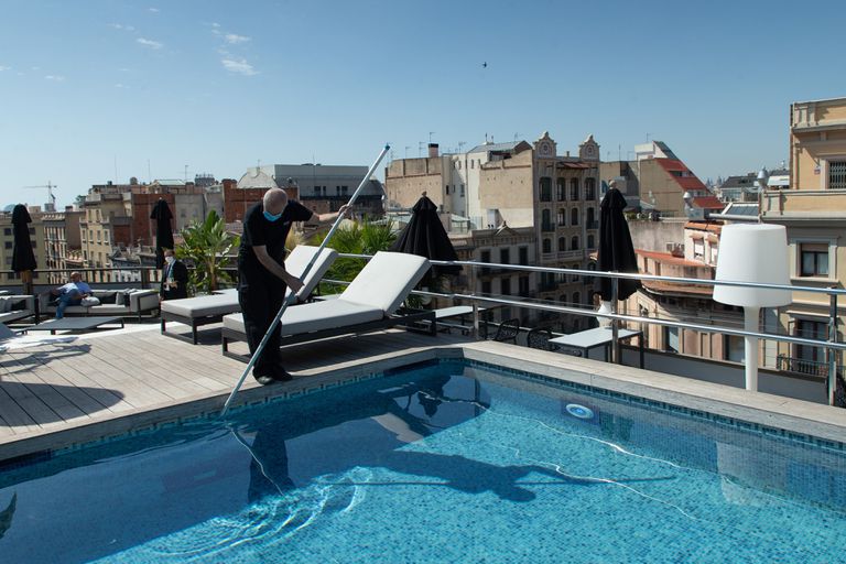 Un trabajador realiza tareas de mantenimiento en la piscina de un hotel de lujo en Barcelona, el verano pasado.