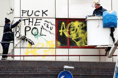 Operarios de limpieza, este lunes, en la comisaría de Bristol  atacada por los manifestantes.