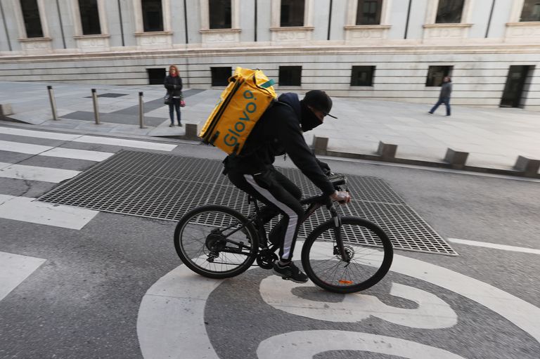 Un ciclista repartidor de Glovo por la Carrera de San Jerónimo de Madrid.