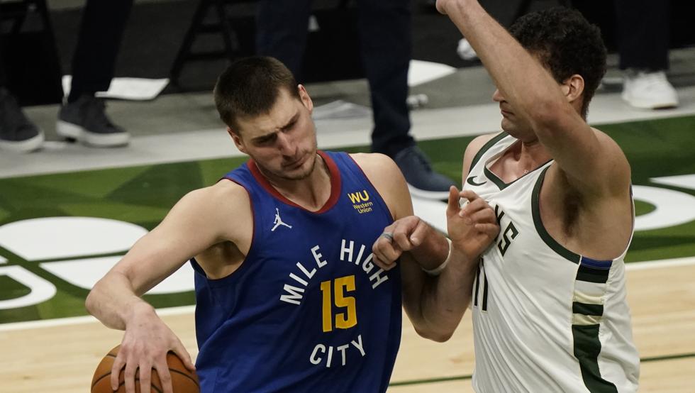 Nikola Jokic ataca frente a Brook Lopez en el Bucks-Nuggets disputado en Milwaukee.