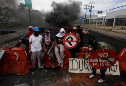 Manifestantes vigilan este lunes una barrera durante una protesta en Cali.