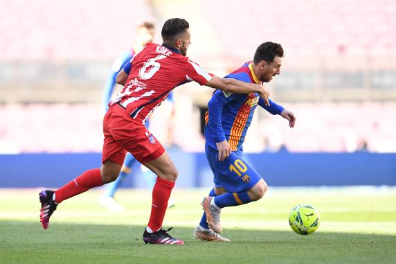 Koke tapando a Lionel Messi durante el partido contra el  FC Barcelona.