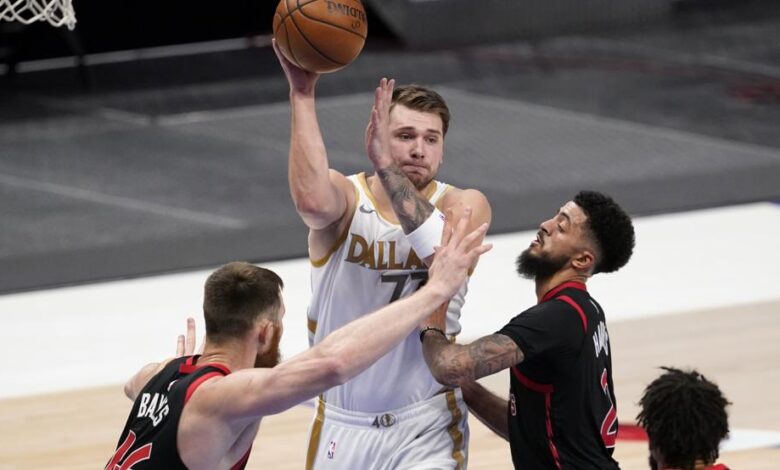 Aron Baynes, Jalen Harris y Khem Birch defienden una jugada de Luka Doncic durante la victoria de los Dallas Mavericks sobre los Toronto Raptors.