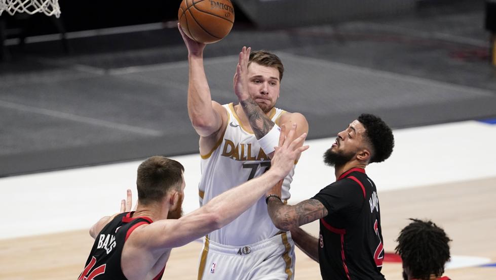 Aron Baynes, Jalen Harris y Khem Birch defienden una jugada de Luka Doncic durante la victoria de los Dallas Mavericks sobre los Toronto Raptors.