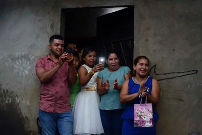 Familiares y vecinos felicitan a la pareja tras el baile en la ceremonia de boda.