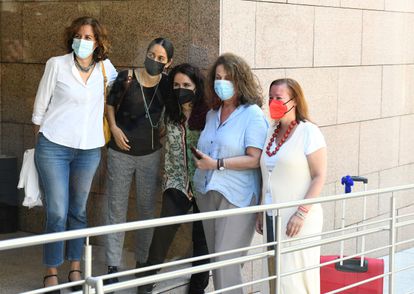 Carla Antonelli, segunda por la derecha, posa para una foto mientras abandona con su maleta la Asamblea de Madrid, este lunes.