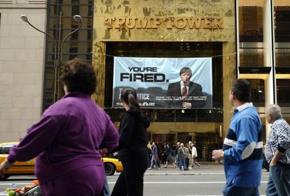 Peatones pasan en 2004 delante de un cartel del programa de Donald Trump El aprendiz, colgado de la Trump Tower, de su propiedad, en Nueva York.
