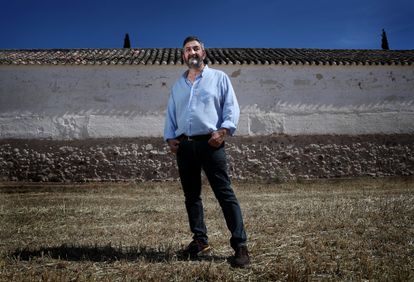 Julián López, catedrático de Antropología Social de la UNED, ante la tapia del cementerio de Almagro donde fusilaban a las víctimas.