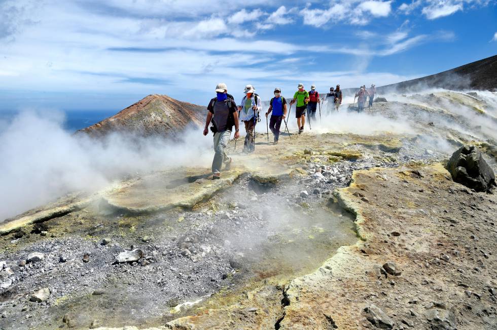 Un grupo de senderistas camina en dirección al Gran Cráter de la Fossa, entre fumarolas de azufre, en la isla italiana de Vulcano.