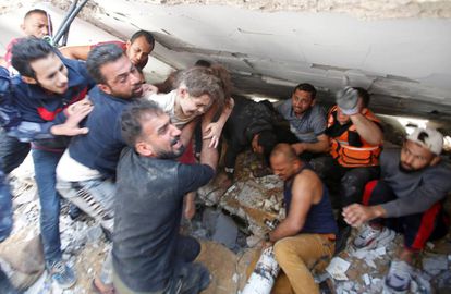 Palestinos rescatan a una niña entre los escombros de un edificio en Gaza, el pasado domingo