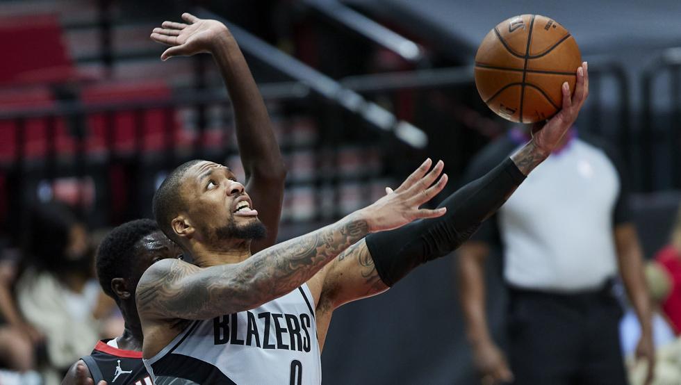 Damian Lillard lanza por delante de Khyri Thomas durante la victoria de los Portland Trail Blazers sobre los Houston Rockets.