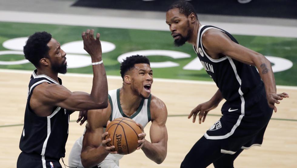 Giannis Antetokounmpo avanza hacia canasta entre Jeff Green y Kevin Durant durante la victoria de los Milwaukee Bucks sobre los Brooklyn Nets.