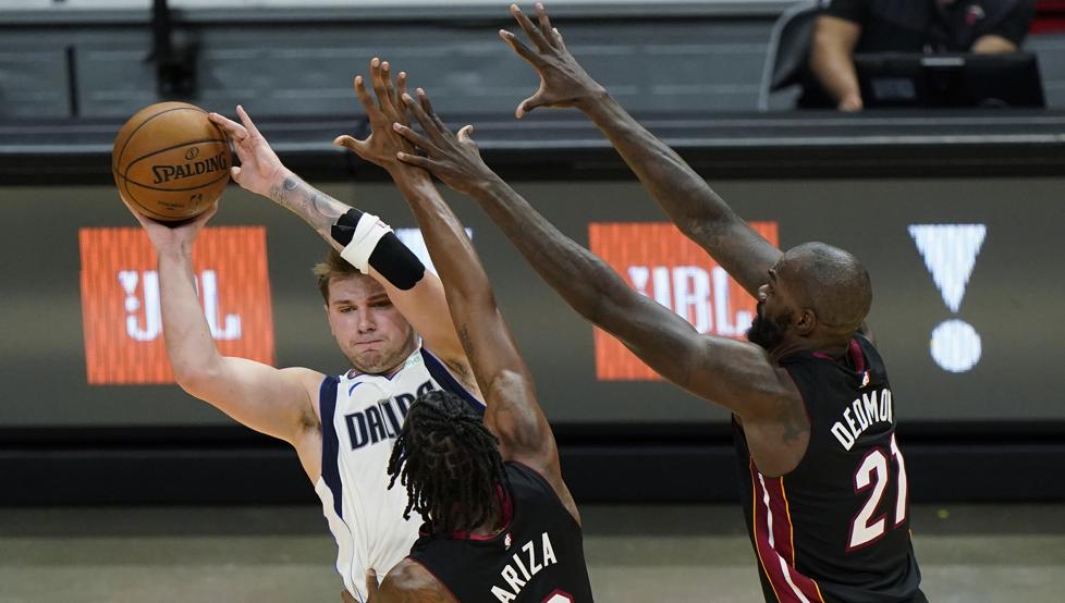 Luka Doncic es defendido por Trevor Ariza y Dewayne Dedmon durante la victoria de los Dallas Mavericks contra los Miami Heat.