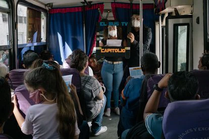 Integrantes del equipo de El Bus TV dan las noticias a los pasajeros de la ruta de Antímano en Caracas, Venezuela, el pasado 20 de mayo.