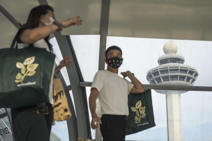 Personas con bolsas de compras en el aeropuerto Changi de Singapur el 10 de mayo.