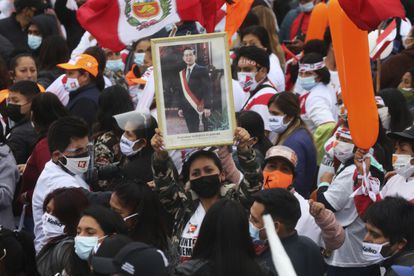 Una seguidora de Keiko Fujimori sostiene un retrato de Alberto Fujimori, su padre, que gobernó de forma autoritaria en Perú de 1992 al 2000, en un mitin el 3 de junio, en Lima.