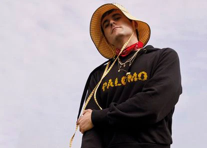 Palomo Spain posa con sudadera con logo y sombrero de su firma.