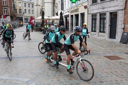 Jaime Lafita, sentado en la parte de atrás del tandem que guía su hijo Diego, y rodeado de los familiares y amigos que le acompañan en el viaje, reemprende la marcha hacia Bruselas desde el centro de la localidad de Halle.  