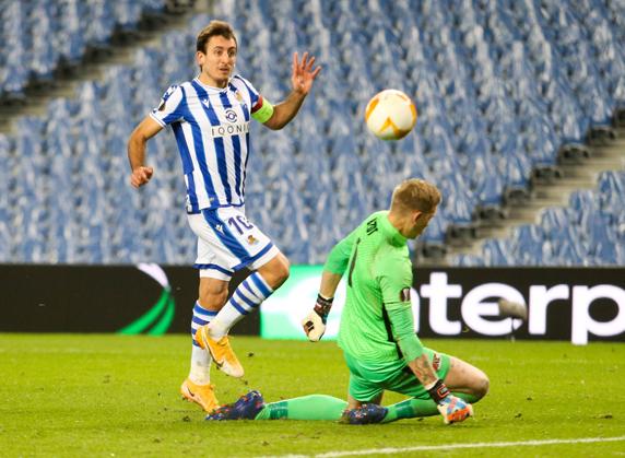 Oyarzabal pica el esférico ante el portero Marco Bizot en el encuentro celebrado en Anoeta