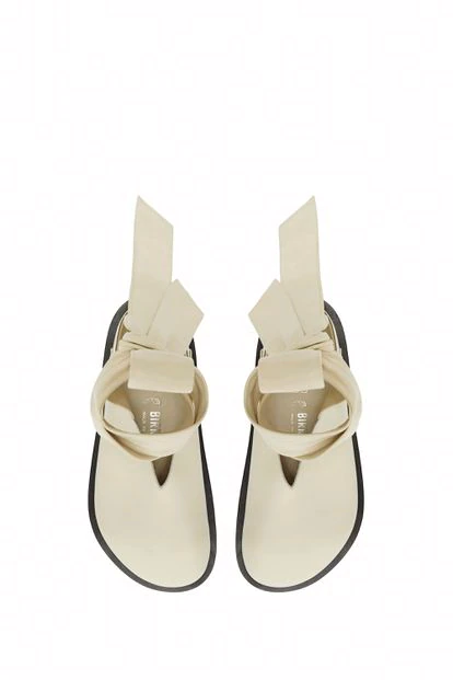 Zueco “Velan” con lazada al tobillo, en piel color arena y suela negra, perteneciente a la colaboración de Jil Sander+ para Birkenstock.