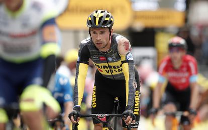 Primoz Roglic cruza la meta con el maillot roto por la caída.