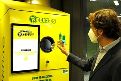 Un usuario deposita una botella de plástico en una de las máquinas de Reciclos en Barcelona.