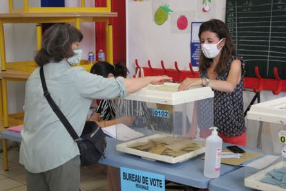 Una electora deposita su voto en un colegio electoral en Marsella, Francia, durante la segunda vuelta de las elecciones regionales.