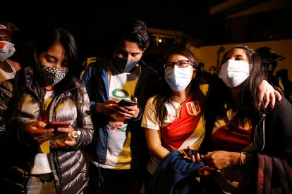 Algunos simpatizantes de Keiko Fujimori revisan sus móviles este domingo en Lima.