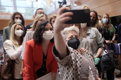 Una mujer se hace un autorretrato con la presidenta de la Comunidad de Madrid, Isabel Díaz Ayuso, en la Asamblea de Madrid el pasado 8 de junio.