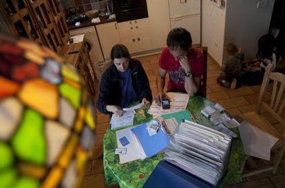 Una pareja revisa sus facturas de agua, luz y electricidad.