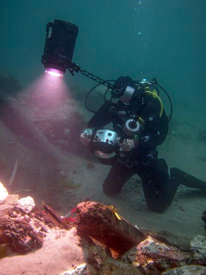 Un arqueólogo graba en alta definición restos de madera del galeón hundido.
