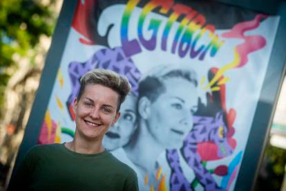 La refugiada LGTBIQ+ Kate posa delante de la campaña de sensibilización del Ayuntamiento de Barcelona de la que formó parte junto con su novia.