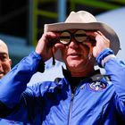 Billionaire American businessman Jeff Bezos wears goggles owned by Amelia Earhart which he carried into space at a post-launch press conference after he flew on Blue Origin's inaugural flight to the edge of space, in the nearby town of Van Horn, Texas, U.S., July 20, 2021. Bezos' brother Mark is on the left. REUTERS/Joe Skipper
