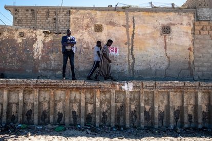 El teniente de alcalde de Saint Louis, Latyr Fall, posa junto al antiguo muro de hormigón, construido en 1930 por el régimen colonial francés para proteger a la ciudad del mar.