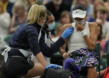 Britain's Emma Raducanu receive medical attention during the women's singles fourth round match against Australia's Ajla Tomljanovic on day seven of the Wimbledon Tennis Championships in London, Monday, July 5, 2021. (AP Photo/Alastair Grant)